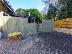 a backyard with a fence and a wheelbarrow with a plant at Calm Clarens in Clarens