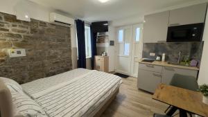 a bedroom with a bed and a stone wall at Morski Val in Piran