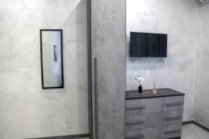 bagno con cassettiera, specchio e TV di Spend Night a Napoli