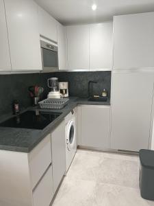 een keuken met witte kasten en een wasmachine bij LES CORAUX AGAY in Agay - Saint Raphael