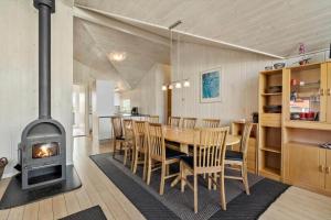 a kitchen and dining room with a wood stove at 614-Hvide-Sande-Rauhesvej-57 in Bjerregård