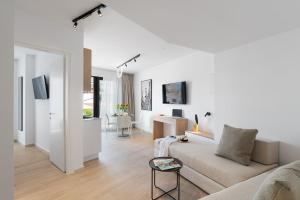 Una sala de estar blanca con un sofá y una mesa. en Neapolis, en La Canea