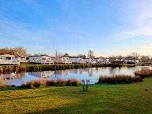 a pond with houses in the background and a lake with ducks at The Humble Bee in Cleethorpes