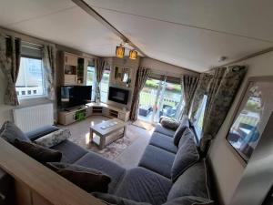 a living room with a couch and a tv at The Humble Bee in Cleethorpes