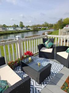 a patio with chairs and a table with a view of a river at The Humble Bee in Cleethorpes