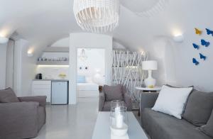 a living room with two couches and a kitchen at Olea Cave House in Imerovigli