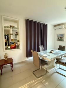 a dining room with a glass table and chairs at Center Oasis Retreat in Podgorica +9 photos