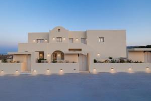 a large white villa with a lit up driveway at Azure Escape in Karterados