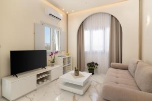 a living room with a couch and a television at Azure Escape in Karterados
