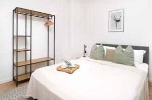 a white bedroom with a large white bed with a shelf at Modernes 3-Zimmer-Apartment - nähe Krankenhaus, Altstadt, Bahnhof - Parken in Amberg