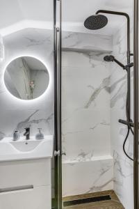 にあるLuxury Villa Pjetraのシャワーと洗面台を備えた白いバスルーム +6枚の写真
