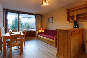 ein Wohnzimmer mit Sofa und Tisch in der Unterkunft travelski home classic - Résidence Meijotel in Les Deux Alpes
