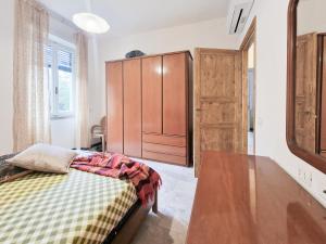 Un dormitorio con una cama y un armario de madera. en Casa La Torre Rio Marina, en Rio Marina