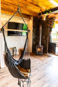 a hammock hanging in a living room with a fireplace at Bieszczadzka Hawira - w Centrum przy Jeziorze z Widokiem dla Rodzin in Polańczyk