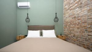 a bed in a room with a brick wall at La casa di Antonio Corfu in Alepou