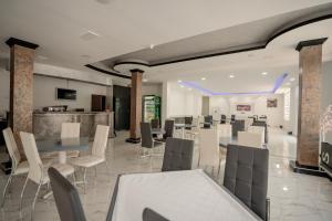 a restaurant with white tables and chairs and a bar at Hotel Vittore in Ohrid
