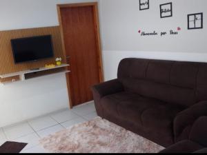 a living room with a couch and a television at Casa da Lu in Aparecida