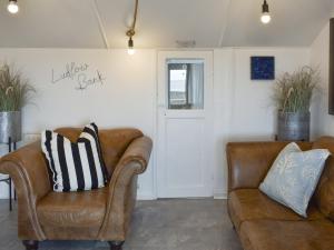a living room with two leather chairs and a door at Ludlow Bank in Caulderton