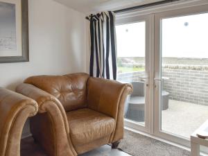 a brown leather chair in a room with a sliding glass door at Ludlow Bank in Caulderton +24 photos