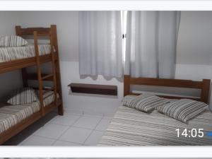 a bedroom with two bunk beds and a window at Casa da Lu in Aparecida