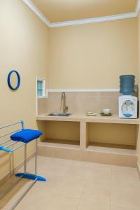 una cucina con lavandino e sedia blu di Bougenville Homestay a Lembar
