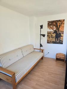 a couch in a room with a picture of a horse on the wall at Ferienwohnung Wiesmoor - Ranch in Wiesmoor