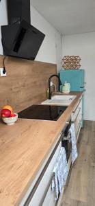 a kitchen with a wooden counter top and a sink at Ferienwohnung Wiesmoor - Ranch in Wiesmoor