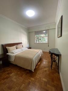 Un dormitorio con una cama y una mesa y una ventana. en Copacabana Beach- 2 Quartos Próximo à Praia, en Río de Janeiro