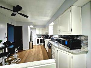 a kitchen with white cabinets and a ceiling fan at Super Comfy Entire Home in Scranton