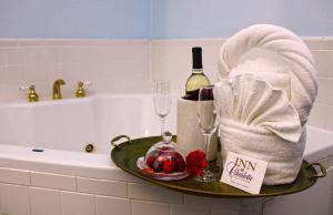 een badkuip met een dienblad waarop een fles wijn en glazen staan bij Inn on Charlotte Boutique Hotel in St. Augustine