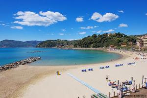 a beach with chairs and people in the water at Il Terrazzo Sul Castello in Lerici