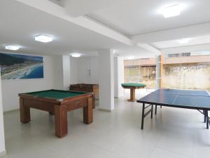 a room with two ping pong tables in it at UBAtubah HOMES 23A 100m Praia Grande WIFI piscina in Ubatuba