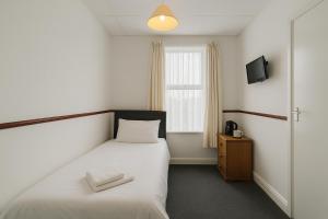 Un pat sau paturi într-o cameră la White Swallow Hotel