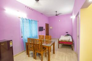 a dining room with purple walls and a table and chairs at riverview homestay in Cochin