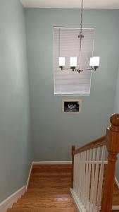 a room with a staircase with a window and a chandelier at Jamani house in Freeport