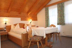 a bedroom with a bed and a table and chairs at Hotel - Wirts'haus "Zum Schweizer" in Lofer