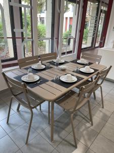 a wooden table with chairs and plates on it at MAISON SAINT CHARLES - ASSOCIATION HABITAT et HUMANISME ILE DE FRANCE in Paris +19 photos