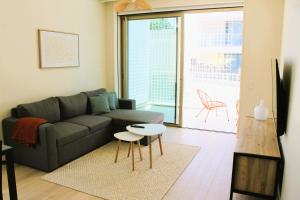 a living room with a couch and a table at Beachside 2 BD Apartment | Balcony | AC in Vila Nova de Gaia
