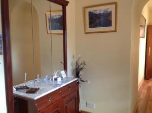 een badkamer met een houten dressoir en een spiegel bij Whitehouse Guest House in Stirling