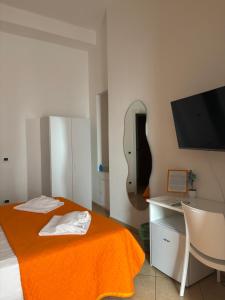 a bedroom with an orange blanket and a mirror at Il dipinto in Reggio di Calabria