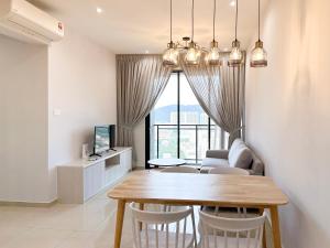 a dining room and living room with a table and chairs at Iconic Regency by Li in Bayan Lepas