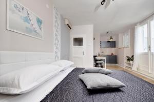 ein weißes Schlafzimmer mit einem großen Bett mit Kissen darauf in der Unterkunft Apartment Mare in Makarska