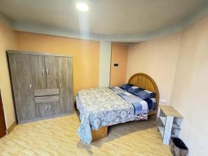 a bedroom with a bed and a wooden cabinet at Mini departamento en Cajamarca in Cajamarca
