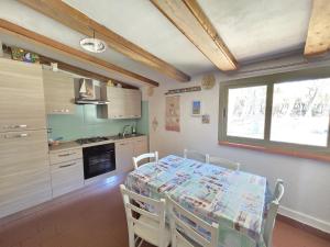 a kitchen with a table and chairs in a room at Appartamento Morelli Beach - La Baracchina sul Mare in Follonica