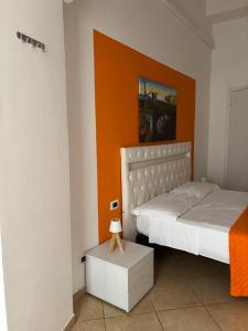 a bedroom with two beds and an orange wall at Il dipinto in Reggio di Calabria