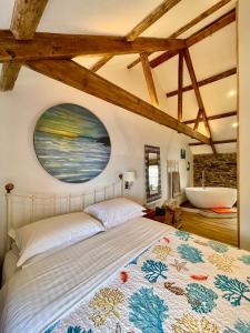 a bedroom with a large bed and a bathroom at Just Opened. Romantic Clifftop Retreat in Portloe