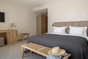 a bedroom with a bed and a table with a hat on it at Alon Sevou Boutique Hotel in Sivota +119 photos