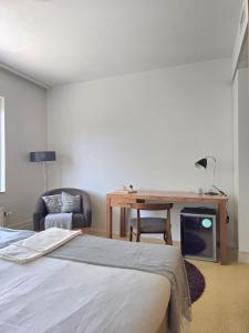 a bedroom with a bed and a desk and a chair at Hotelli Sammatti in Lohja