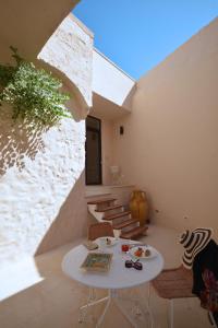 a room with a white table and chairs and stairs at I Bastioni San Domenico - Boutique Hotel in Gallipoli