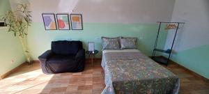 a room with a bed and a chair in it at Apê Estúdio Rodrigues 02 in Paranaíba